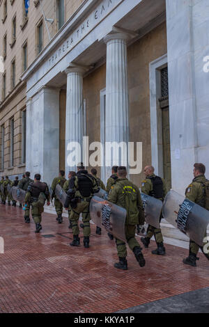 ATHENS, Grecia - 18 novembre 2017: Riot Police con il loro scudo, prendere la copertura durante il raduno di fronte all Università di Atene, che è sotto l'occupazione b Foto Stock