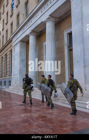 ATHENS, Grecia - 18 novembre 2017: Riot Police con il loro scudo, prendere la copertura durante il raduno di fronte all Università di Atene, che è sotto l'occupazione b Foto Stock