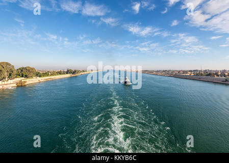 Nave passando attraverso il canale di Suez in Egitto. rimorchiatore che accompagna le navi. Foto Stock
