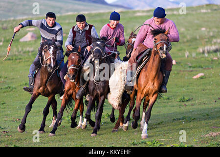 Le popolazioni nomadi cavalieri grabbing carcassa di capra da ogni altro, durante il cavallo tradizionali giochi noti come buzkashi o kok par, in Issyk Kul, Kirghizistan. Foto Stock