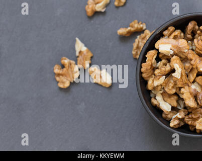 Wallnuts nella ciotola sul tavolo grigio Foto Stock