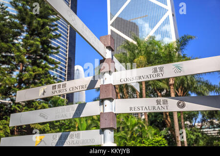 Hong Kong, Cina - 7 dicembre 2016: Indicazione turistica del Peak tram e Olympic Square presso l'Hong Kong Park. Bank of China e moderni grattacieli di Foto Stock