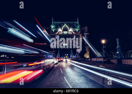 Città sentieri di luce rossa di Londra il traffico sul bus il Tower Bridge di Londra di notte Foto Stock