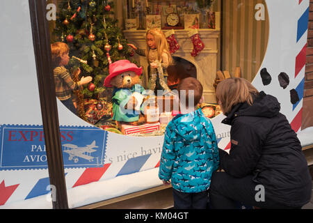 Le persone che ricercano Fenwick's 2017 Paddington Bear display di Natale, Newcastle upon Tyne, England, Regno Unito Foto Stock