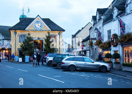 Gli amanti dello shopping natalizio curiosano tra la festosa Market House e i negozi vicini a Tetbury Foto Stock