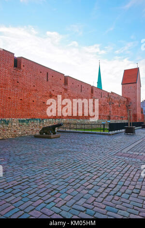 Riga, Lettonia - 26 dicembre 2011: rosso mattone di mura difensive e cannoni nel centro storico della città vecchia di Riga, Lettonia. Foto Stock