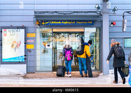 5 marzo 2017 - rovaniemi, Finlandia: coppia giovane con valigie all'ingresso nell'aeroporto di Rovaniemi in inverno Foto Stock