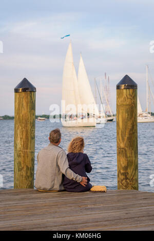 Un giovane abbraccia come una barca a vela si fa strada in porto, Città Dock, Annapolis, Maryland Foto Stock