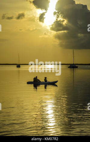 Keywest tramonto tramonto a key west florida usa con la barca e flottante silhouette di persone ora d'oro Foto Stock