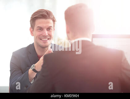 Business Partner per discutere in sala riunioni con il loro collega Foto Stock