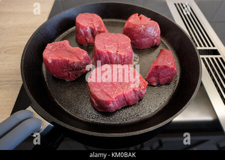 Materie di filetto di manzo tostatura in una ghisa padella su una stufa Foto Stock