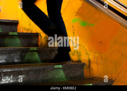 Un uomo gambe risalendo la vecchia città metropolitana scale in motion blur Foto Stock