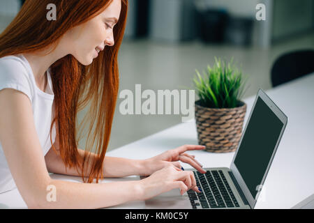 Donna digitando su laptop al lavoro donna che lavorano in ufficio a casa la tastiera a mano Foto Stock