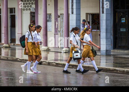 Quattro ragazze della scuola si rompono per il pranzo e si meravigliano per le strade di Moron, la capitale del distretto di Ciego de Avila di Cuba. Foto Stock