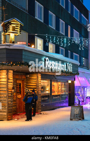 Rovaniemi, Finlandia - 1 marzo 2017: persone al ristorante tradizionale in inverno rovaniemi, Finlandia. illuminata di notte Foto Stock