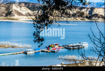 Lungo il molo di legno circondato da imbarcazioni al California's Lake Cachuma vicino a Los Padres National Forest con San Rafael montagne in distanza Foto Stock