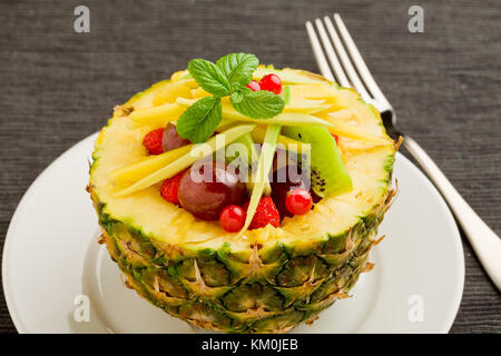 Foto di deliziosi dessert ananas ripieni di frutta tropicale Foto Stock