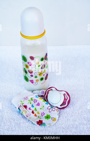 Baby stuff isolati su sfondo bianco. Impostare per la ragazza neonata con latte per neonati, giocattolo, il succhietto, anti graffio protezione mano guanti e calze in backgr bianco Foto Stock