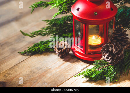 Rosso lanterna di natale con candela su sfondo di legno Foto Stock