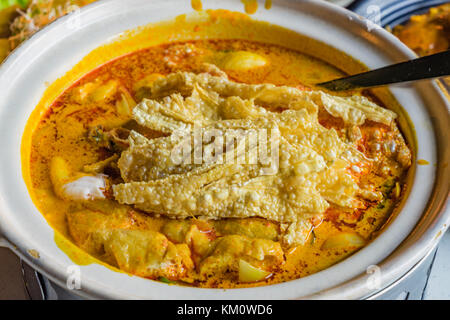 Cinese di pesce al curry zuppa, mappas king fish curry con latte di cocco la crema in una ciotola bianco Foto Stock