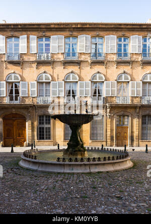 La vecchia fontana in un cortile in ciottoli con stucco tre storia appartamenti edificio con persiane e porte di legno intagliato e windows con ripide whit Foto Stock
