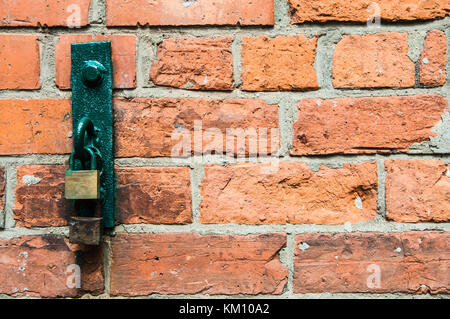 Cerchio in acciaio su una parete con lucchetti attaccati Foto Stock
