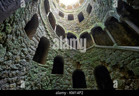 Una scala discendente a spirale lungo le pareti del pozzetto di iniziazione (invertito) torre in Quinta da Regaleira station wagon. Sintra, Portogallo Foto Stock