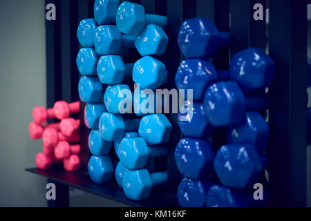 Manubri colorati sulla piramide in palestra Foto Stock