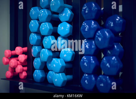 Manubri colorati sulla piramide in palestra Foto Stock