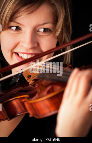 Giovane ragazza sorridente e suonare il violino Foto Stock