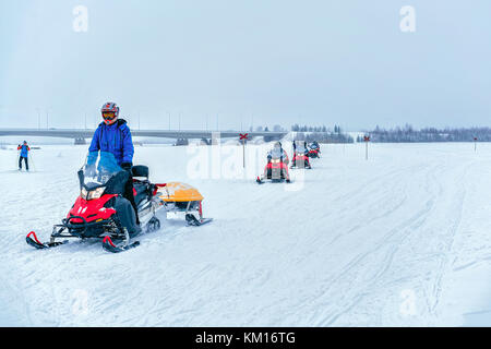 Rovaniemi, Finlandia - 2 marzo 2017: gli uomini a cavallo delle motoslitte sul lago ghiacciato in inverno rovaniemi, Lapponia, Finlandia Foto Stock