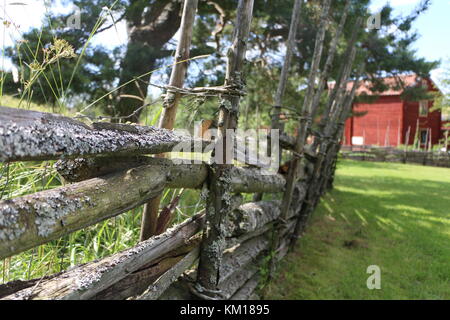 Svedese Tradizionale staccionata in legno con red farm house in background Foto Stock