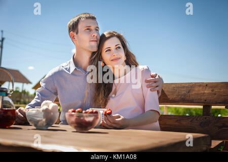 Futura Mamma e papà di mangiare fragole all'aperto Foto Stock