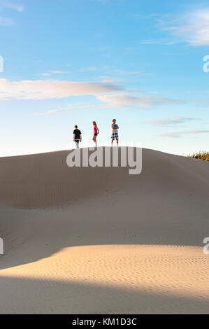 Tre adolescenti camminando sul bordo di dune di sabbia in Oceano Dunes State Vehicular Recreation Area, Oceano dune naturali preservare, California, Stati Uniti d'America. Foto Stock