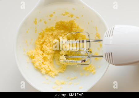 Preparazione di pasta biscotto con le fruste elettriche nel recipiente Foto Stock