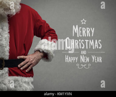 Fiducioso santa claus in posa con bracci akimbo close up e auguri di Natale Foto Stock