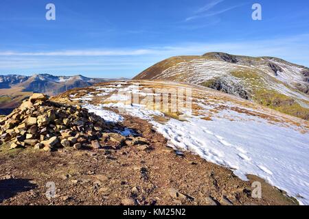 Cairn sulla cicatrice falesie con vela e balza al di là di collina Foto Stock