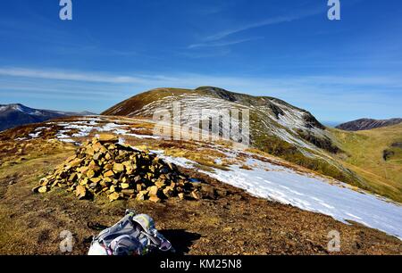 Cairn sulla cicatrice falesie con vela e balza al di là di collina Foto Stock