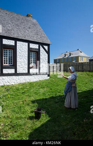 Membro del personale in abito d'epoca con uova di pollo alla Fortezza Louisbourg, Capo Breton, Nuova Scozia, Canada. Foto Stock