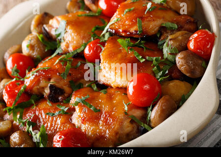 Cosce di pollo al forno con le castagne e i pomodori vicino fino in una ciotola. orizzontale Foto Stock