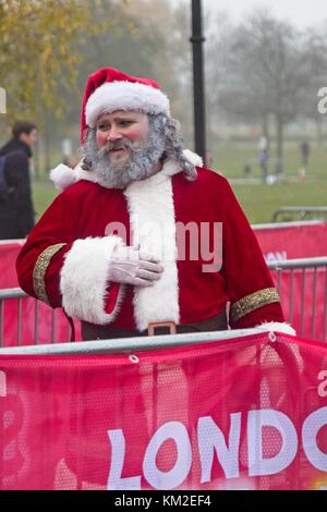 Londra, Regno Unito. 3 dicembre, 2017. guide, per chi ama fare jogging e walkers vestito in costumi santa coraggioso il drizzly meteo di partecipare nel 2017 santa dash per carità, su clapham common a Londra, Regno Unito. Credito: n papa - EDITORIALE/alamy live news. Foto Stock