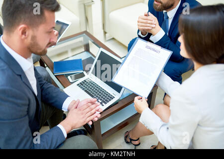 I partner a discutere di contratto business in riunione Foto Stock