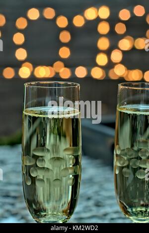 Anno nuovo concetto di decorazione-due bicchieri di champagne su un sfocata fondo oro nuovo anno. Foto Stock