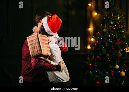 Uomo natale dando presente alla sua ragazza Foto Stock