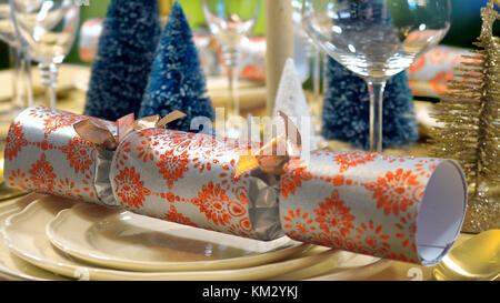 Festa di Natale tavolo pranzo in moderno oro, rame e bianco tema contro un giardino esterno finestra Impostazione. Foto Stock