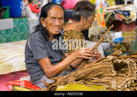 Elderley della donna nel mercato del carbonio,Cebu City vendita di foglie di tabacco Foto Stock