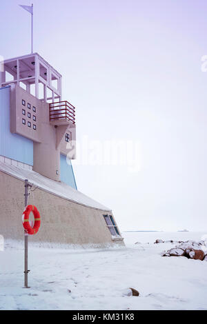 Salvagente e il faro nel mar Baltico in inverno oulu, Lapponia, Finlandia. Foto Stock