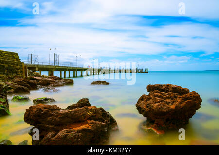 Cowes pier nel mezzo di una liscia come seta mare Foto Stock