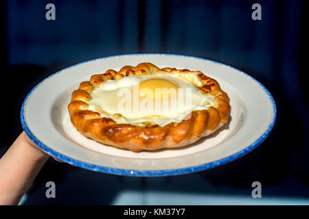 Close up donna trattiene la piastra con khachapuri Foto Stock