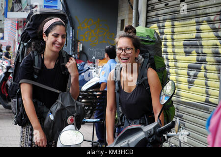 Ho chi minh city, Viet Nam, due donna caucasica, femmina asiatica in vacanza da backpacking viaggiare su strada di Saigon, bella traveler con la faccia felice Foto Stock